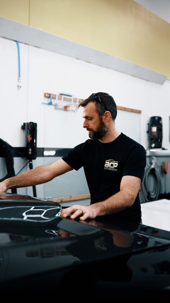 A man is performing a ceramic coating installation on a car